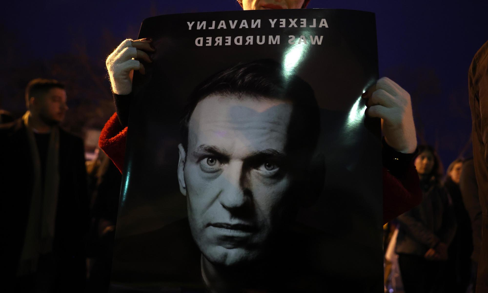在守夜期间，支持者们举着一张印有阿列克谢·纳瓦尔尼面孔的海报，上面写着“阿列克谢·纳瓦尔尼被谋杀”.