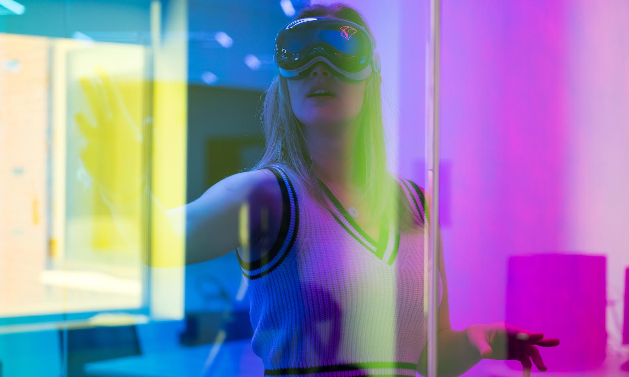 Student uses VR glasses and is pictured through a rainbow prism